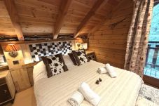Dormitorio con cama de matrimonio y TV